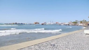 Kayalık plajda ayakta iken telefon selfie fotoğrafları yapıyor ile genç güzel beyaz kız. Dalgalar kayalar üzerinde sıçramaya