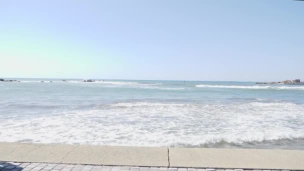 Joven hombre caucásico en forma atractiva en negro trotando en un muelle. Moción lenta — Vídeos de Stock