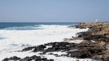 Kayalık plaja çarpan güçlü deniz dalgaları. Kayalık plaj üzerinde deniz dalgaları sıçraması. Yavaş hareket