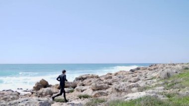 Kafkas atletik adam çalışır ve deniz kıyısı boyunca kayalar üzerinden atlar. Yavaş hareket