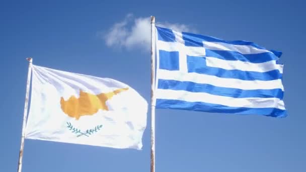 Cyprus flag and Greek flag flapping in wind on a pole. Blue sky and cyprus and greek flags. Slow Motion — Stock Video