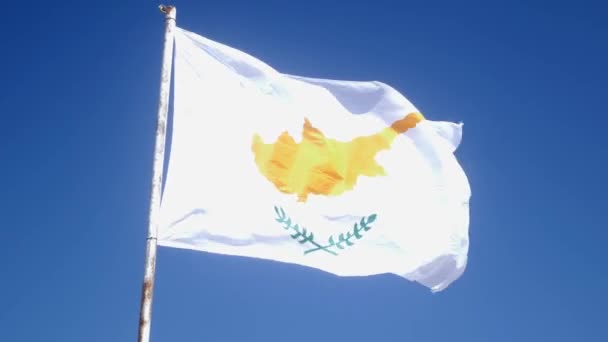 Kyperská vlajka se chvěje ve větru na tyči. Modrá obloha a kyperská vlajka. Zpomaleně — Stock video
