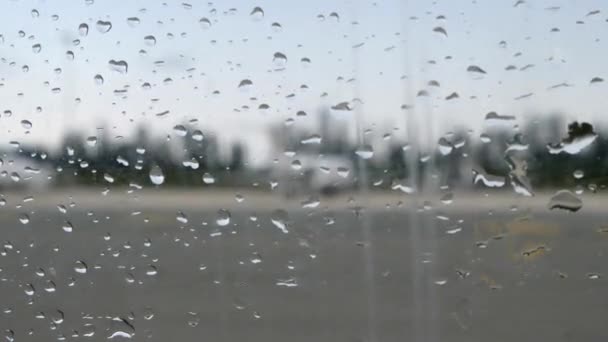 Airplane window with raindrops. Blurry view of the airplane through the plane window with rain drops — Stock Video