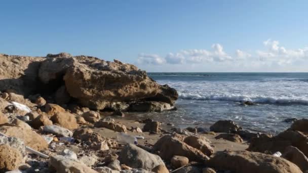 Ocean rocky beach polluted with plastic garbage. Earth pollution. — Stock Video