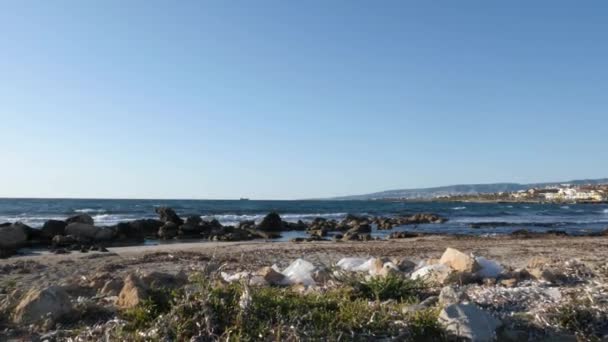 Odpady plastikowe i śmieci z kupą śmieci na piaszczystej plaży. Statek w morzu na tle. Zwolnionym — Wideo stockowe