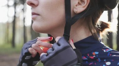 Odaklanmış bisiklet kadın triatlon yarışı öncesi kask ve klipler koşum koyar. Triatlon konsepti. Yavaş çekim