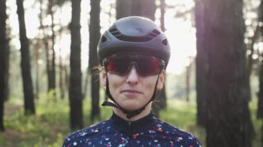 Çekici genç beyaz kadın siyah kask ve mayo giyen bisiklet gözlük kapalı koyar. Triatlon konsepti. Yavaş çekim