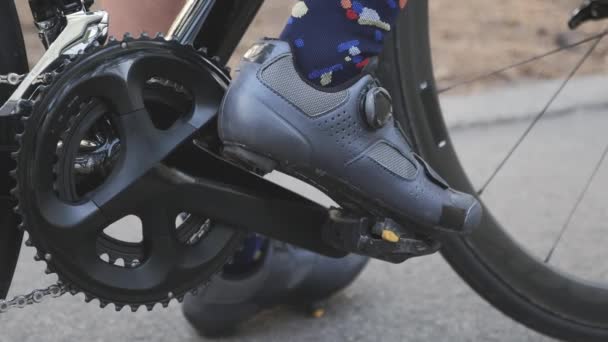 Mujer ciclista deportiva recorta los zapatos de carretera de los pedales. Concepto de ciclismo. Movimiento lento — Vídeo de stock