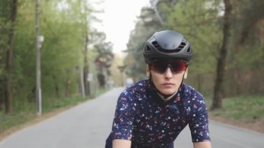 Çekici kuskusasyalı kız bisikletsürme başlar. Bisiklete odaklanmış bir kadın. Bisiklette helment ve gözlük takan kız.
