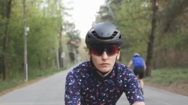 Çekici kuskusasyalı kız bisikletsürme başlar. Bisiklete odaklanmış bir kadın. Bisiklette helment ve gözlük takan bir kız. Yavaş çekim