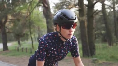 Sportif odaklı proffessional bisikletçi kadın eyer dışında bir bisiklet sürme. Atış ları takip et. Yol bisikleti konsepti. Yavaş çekim