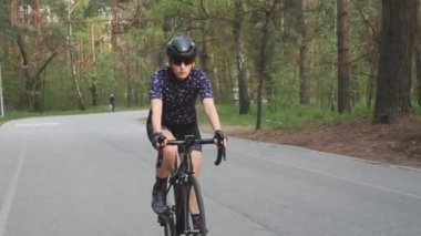 Parkta bisiklete binen kadın. Bisiklet eğitimi. Ön takip atışı. Bisiklette fitness. Yavaş çekim