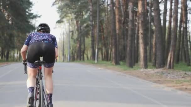 Ženská roztomilá cyklistka jede na kole v parku jako součást tréninkové rutiny. Cyklistický koncept. Zpomaleně — Stock video