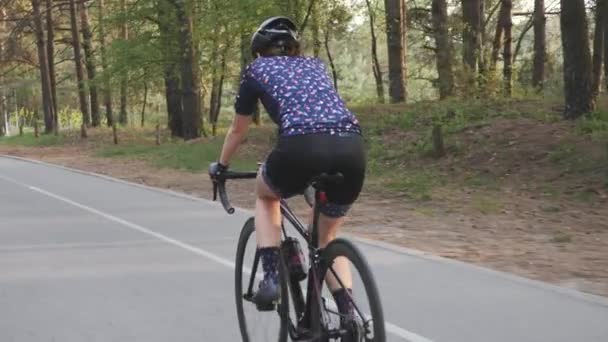 Mujer ciclista deportiva activa montar en bicicleta en el parque. Entrenamiento en bicicleta. Paseo en bicicleta. Movimiento lento — Vídeo de stock