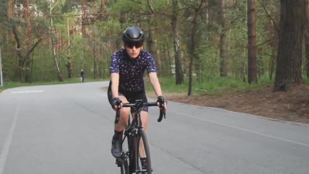 Uma mulher a andar de bicicleta no parque. Treino de ciclismo. Tiro à frente. Aptidão na bicicleta. Movimento lento — Vídeo de Stock