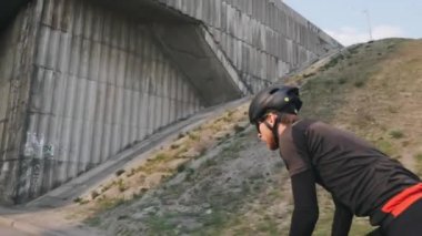 Siyah kask ve güneş gözlüğü takmış, bisiklete binen genç ve formda bir bisikletçi. Bisiklet kavramı.