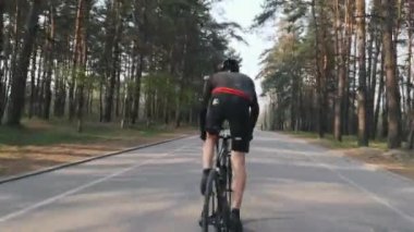 Profesyonel bisikletçi parkta eyer dışarı sprints. Bisiklet eğitimi. Bisiklet konsepti.