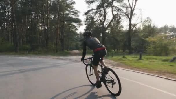 Уверенный сильный триатлонист крутит педали на велосипеде в парке как парк своего графика тренировок для гонки. Концепция триатлона . — стоковое видео