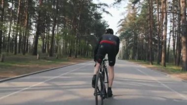 Profesyonel bisikletçi parkta eyer dışarı sprints. Bisiklet eğitimi. Bisiklet konsepti. Yavaş çekim