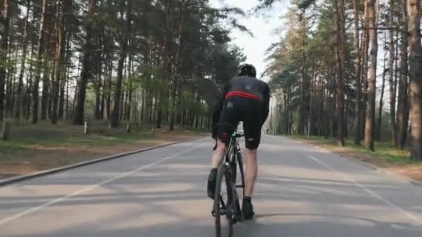 Ciclista profesional sale corriendo de la silla de montar en el parque. Entrenamiento en bicicleta. Concepto de ciclismo. Movimiento lento — Vídeo de stock