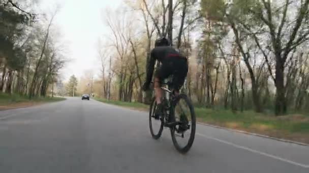 Forte triatleta confiante andar de bicicleta no parque. Seguir tiro nas costas. Conceito de triatlo . — Vídeo de Stock