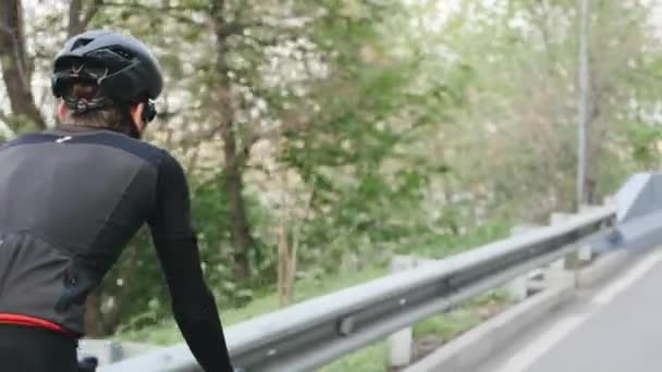 Fahrradfahrer in schwarz-rotem Outfit auf Fahrrad im Park. wieder Nahaufnahme Folgeschuss. Radverkehrskonzept. — Stockvideo