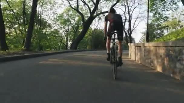 Fuerte ciclista profesional cabalga cuesta arriba desde la silla de montar. Fuertes músculos atléticos de las piernas pedaleando bicicleta . — Vídeos de Stock