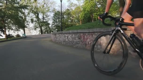 Fuerte ciclista escalando montaña de cerca seguir disparo. Músculos de piernas delgadas fuertes. Fuera de la técnica de ciclismo silla de montar. Movimiento lento — Vídeos de Stock