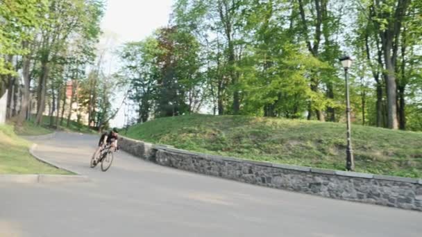 Profesjonalny silny chudy rower jeździec malejąco na krzywego drogowego ubrany w czarną koszulkę i szorty. Rowerzysta zejściem na wzgórze. Zwolnionym — Wideo stockowe