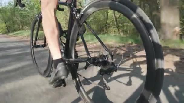 Músculos fuertes de la pierna del ciclista pedaleando en bicicleta. Siga la toma de cámara de las piernas del motociclista en movimiento en bicicleta. Movimiento lento — Vídeo de stock