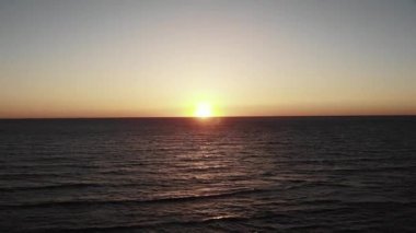 Deniz okyanusunda gün batımı. Arka planda gökyüzü ve deniz ile batan akşam güneşi. Baharda Baf Kıbrıs gün batımı.