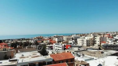 Arka planda dağlar ve deniz ile Kıbrıs şehir baf drone havadan 360 çekim. İş merkezleri ve güneş pilleri drone manzaralı binaların çatıları