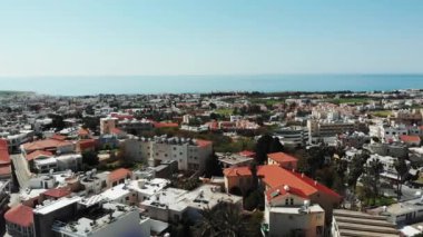 Yaz güneşli gününde çatıları ve binaları ile baf şehrin havadan çekilmiş. Arka planda deniz ile Kıbrıs şehir üzerinde Drone.