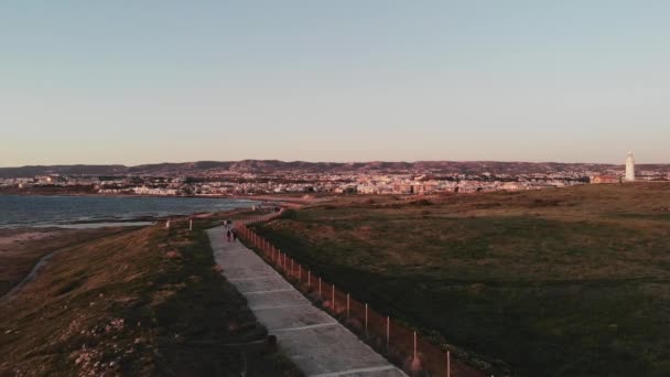 Aerial drone shot of peestrian path along mediterranean sea with lighthouse in Paphos Cyprus — Vídeo de stock