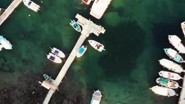 桟橋の近くに浮かぶ漁師のボートとヨットと港湾の空中トップビュー。都市港のドローンショット — ストック動画