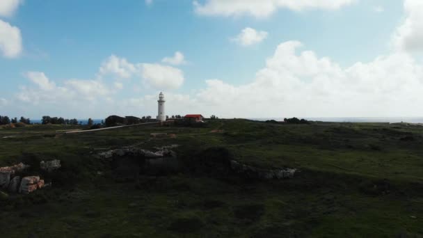 Drone shot van vuurtoren in de buurt van zee met stad op de achtergrond. Cyprus Island, Paphos — Stockvideo