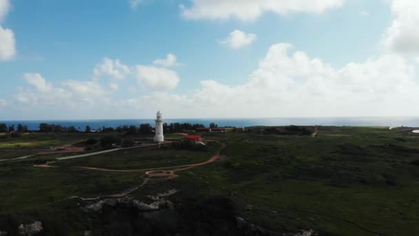 Aerial utsikt över fyren och havet i horisonten med blå himmel och grönt gräs. Cypern Paphos. — Stockvideo