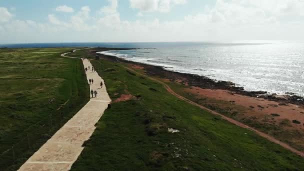 Légifelvételek a tenger partvidékről gyalogosokkal sétálva a tengerparton. Paphos ciprusi sétány. Drone kilátás a tengerre és a tengerpart gyalogos úton — Stock videók