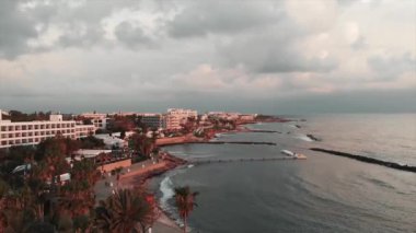 Gün batımında yaya yolunun drone görünümü. Gezinti yolunda gün batımı. Mutlu insanlar gün batımında gezinti yolunda yürüyorlar. Gün batımında turistik alanın havadan görünümü.