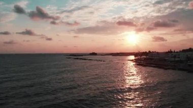 Gün batımında iskelenin drone atışı. Gün batımında dalgalar ile okyanusun havadan görünümü.