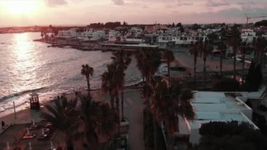 Gün batımında gezinti ve kafeler ile turistik alanın havadan drone görünümü. Mutlu turistler gün batımına bakarak rahatlatıcı