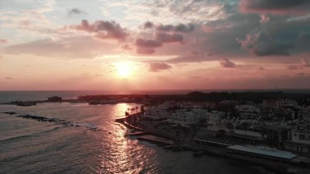 Pohled na západ slunce s větrnou vodou a molo. Vlny dopadajícího na břeh moře. První záběr městského přístavu. — Stock video