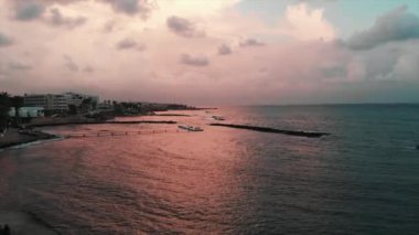 Gün batımında okyanus ayakın iskele boyunca yürüyen insanların drone atışları. Gün batımında turistik gezinti ile okyanus havadan görünümü.
