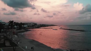 Güneş yolu ile yaya yolu ve palmiye ağaçları ile güzel okyanus günbatımı Drone çekim