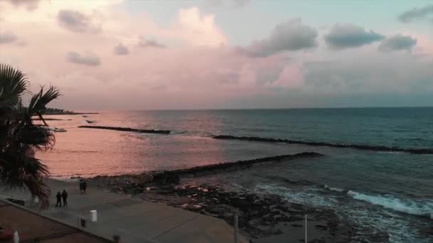 Flygvy över lyckliga avslappnade turister som går längs strandpromenaden och njuter av semester nära Medelhavet vid solnedgången — Stockvideo