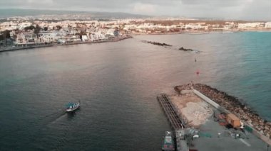 Gün batımında inşaat ile güzel şehir limanından açık denize yelken küçük beyaz tekne havadan drone atış