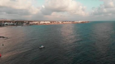 Güneşli yaz gününde beyaz balıkçı teknesinin drone görünümü güneşli yaz gününde şehir dışına çıkarak Akdeniz'e açılıyor