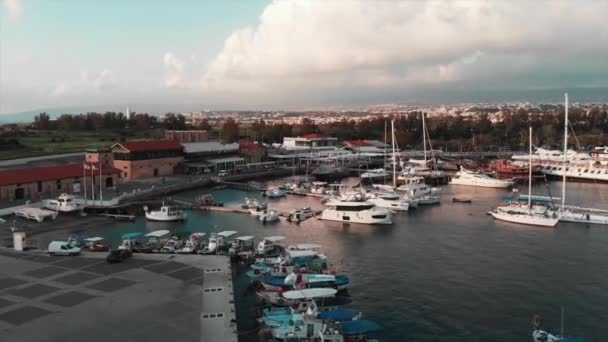 Drone view of tourist quay with boat starting to sail with city with mountain landscape on the background — Stock Video