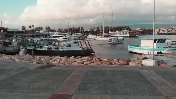 Aerial drone view of fishing boats at city quay with tourist pedestrian path — Stock Video