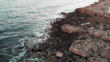 Büyük taşlar ve yan beyaz mimari yapısı ile kayalık deniz plaj drone görünümü